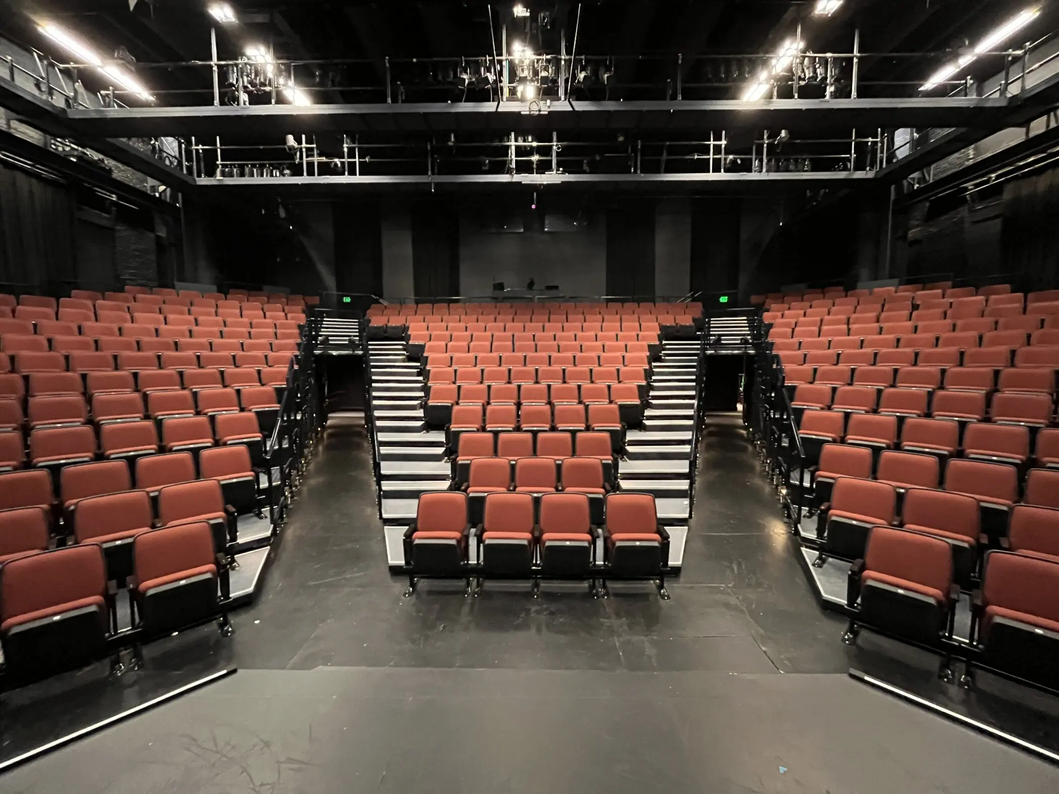 Three sections of red theater seats on riser platforms.