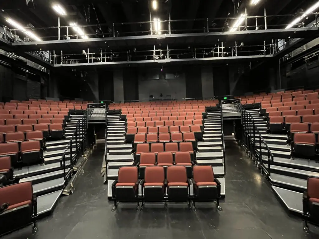 IMG_0526 Three sections of red theater seats on riser platforms.