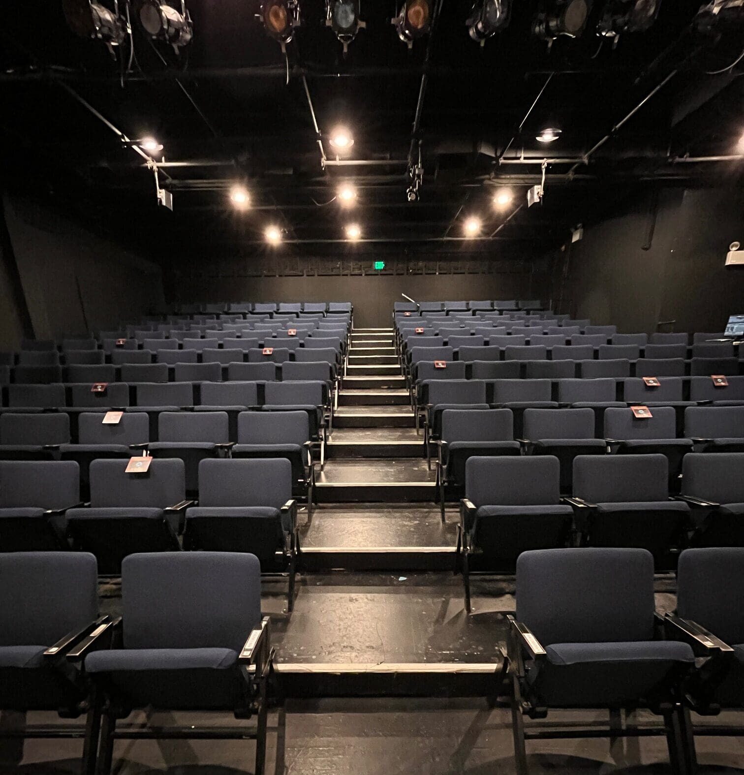 One sections of blue theater seats on riser platforms.